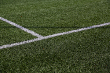 Artificial turf soccer field where we can see the goals, the corner with its flag, and the white lines.