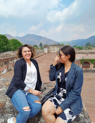 Dos mujeres latinas de viaje por Antigua Guatemala, sonriendo mientras disfrutan de sus vacaciones.