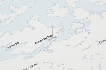 macro photo of a white pin needle into cambridge bay city of Canada political map
