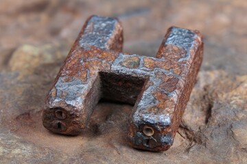 Rusty metal piece on rocky surface.