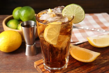 Refreshing Cuba libre cocktail and ingredients on wooden table, closeup