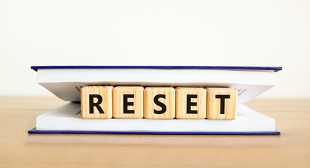 Reset symbol. Concept word Reset on beautiful wooden blocks in book. Beautiful wooden table white...