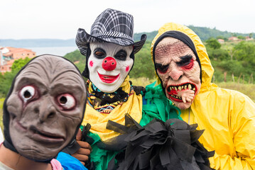 Unidentified people dressed in terrifying costumes in a rural area.