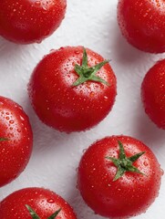 Tomatoes with water droplets, arranged on a clean white surface.