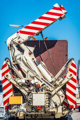 Large blue construction equipment with hydraulic components and chains at a worksite against a...