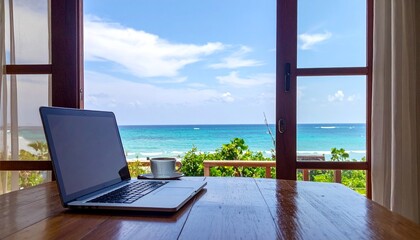Fototapeta premium A laptop on a wooden table with a view of the ocean through open French doors – Remote Work & Digital Nomads 