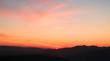 Fototapeta premium Pink and Orange Sunset Over Silhouetted Mountains