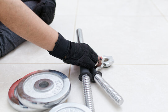 Athlete preparing adjustable dumbbells for home workout