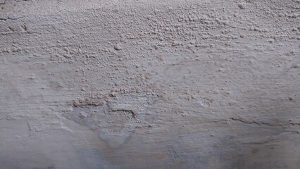 Rough and Worn Wall Texture. A photograph showcasing the distinctly rough and worn texture of an aged wall. Ideal for backgrounds or illustrating weathered surfaces.