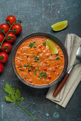 Authentic Brazilian moqueca de camarao, a rich seafood stew with shrimp, tomatoes, peppers, and lime, garnished with parsley and served in a rustic bowl on dark blue background