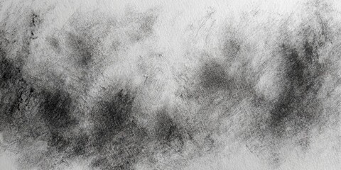 Close-up of black charcoal shading on white textured sketchbook paper
