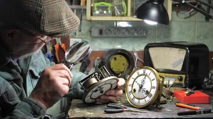 Vintage clockwork. The hands of an old master carefully adjust an antique clockwork, bringing it back to life. Restoration of antiques.