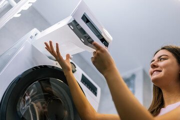 Girl Removing Water Container from Dryer Machine