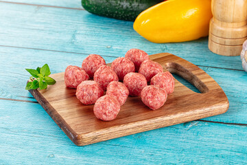 Raw beef meatballs over board
