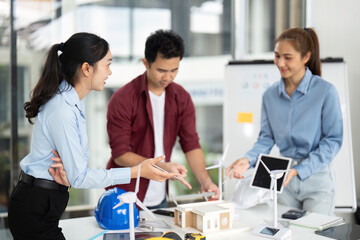 Engineer Collaboration on Sustainable Project. Team discussing renewable energy models in modern office.