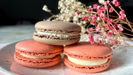 colorful macarons with cream filling on plate, elegant dessert with dried flowers, perfect for gourmet and celebration themes
