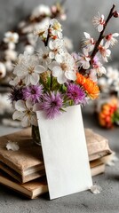 Beautiful spring bouquet with vibrant flowers and a blank card on vintage books in a cozy setting