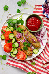 Chicken Lula Kebab with fresh vegetables and hot sauce on a platter.top veiw