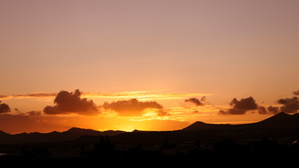 Sunset view with clouds, horizon with silhouettes of mountains