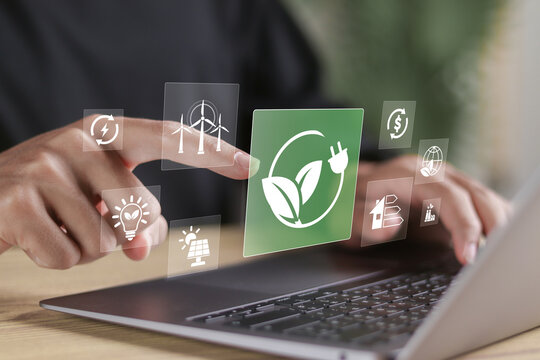 Renewable energy sources and alternative energy sources concept. Person using laptop with renewable energy icons on virtual screen. - Powered by Adobe