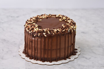 Rich Chocolate Drip Cake with chocolate Shavings covered in a smooth chocolate ganache that...