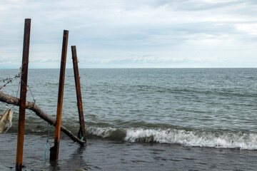 A wooden post is sticking out of the water