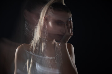 Fashion portrait of beautiful model in silver top and silver jewelry. Motion blur added...