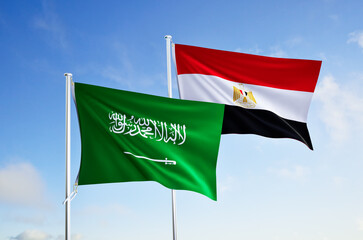 flags of saudi arabia and egypt over blue sky background.