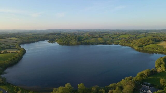 Wide high aerial drone view of blue lake in green Irish countryside. Emy Lough, Monaghan, Ireland