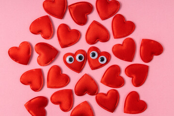 Lot of red love hearts as decoration.Hearts with googly eyes close to each other as symbol of warm relation