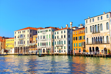 Colorful buildings line the Grand Canal, reflecting the vibrant atmosphere of Venice. Venetian canalside architecture, showcasing a vibrant array of pastel hues along the water's edge