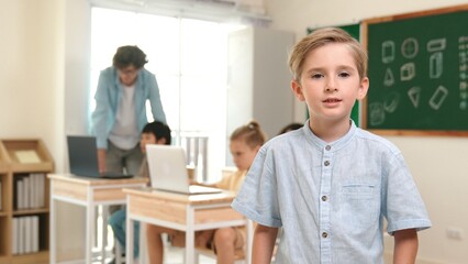 Caucasian cute student looking at camera while friend studying about writing engineering code or...