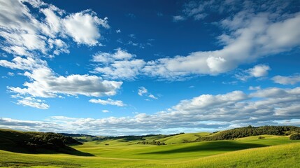 Vast open landscape of smooth rolling green hills under bright daylight, scattered white clouds drift across vibrant blue sky, no visible buildings or objects. Generative by AI