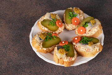 Sandwiches with salted herring, melted cheese, carrot and pickled cucumber
