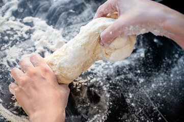 Kneading the dough. Traditional Ukrainian varenyky stuffed with cottage cheese &mdash; step-by-step process of home cooking. Hands at work, fresh ingredients and real Eastern European 