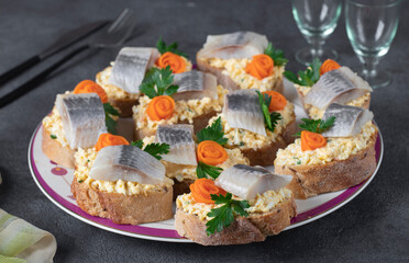 Homemade sandwiches with salted herring, cheese and egg, decorated with carrot and parsley, Closeup