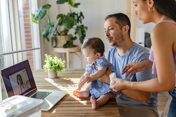 Hispanic family having video call with pediatrician using laptop at home