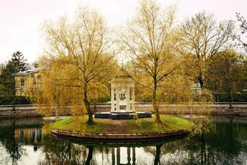 Gazebo on an island in a pond in a city park.