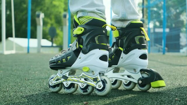 Close up roller blades. Roller skating girl kid in park rollerblading on inline skates.