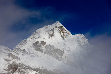 Mera Peak high altitude mountain summit ascent in Himalayas. Stunning views above the clouds at sunrise from the top of the mountain. Alpine route climbing on the snow path in Himalayas
