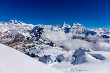 Mera Peak high altitude mountain summit ascent in Himalayas. Stunning views above the clouds at sunrise from the top of the mountain. Alpine route climbing on the snow path in Himalayas