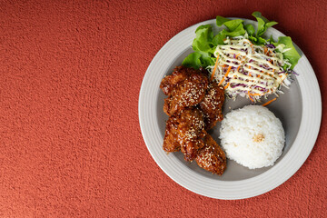 Asian style crispy deep fried chicken topped with savory sauce served over steamed rice