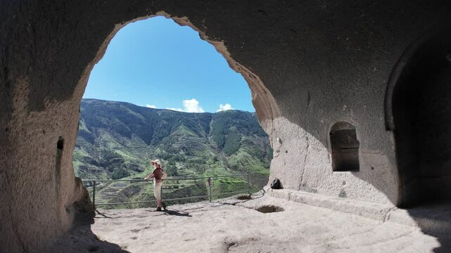 Tourist admiring the breathtaking landscape from within the Vardzia cave monastery, a medieval site carved into Erusheti Mountain in Georgia