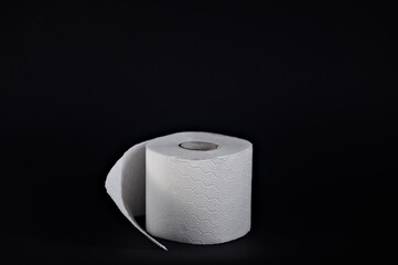 Soft white toilet paper roll placed against a dark background, highlighting its hygiene purpose