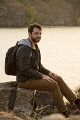 Young man on the cliff above river