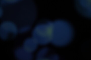 Christmas lights in bokeh. Outside in December. Snow and blue bokeh on a black background, bokeh abstract background, modern technological abstract background. Blue Christmas background, Xmas bokeh 
