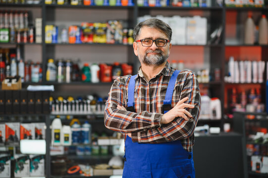 Salesman smiling with crossed arms in auto parts store