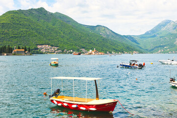 PERAST, MONTENEGRO - MAY 06 2024: Tourists are relaxing on the sea and walking on the street, on May 06, 2024 in Perast, Montenegro. During spring on a sunny day.