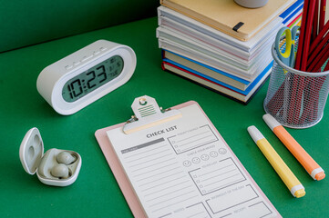 Colorful school supplies on a green background