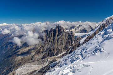 Aiguille du Midi peak above the clouds from the ascent to the summit of Montblanc view. Snow...